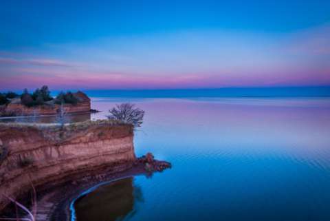 Sunrise over cliffs in front of a lake, Great Salt Plains State Park, Oklahoma